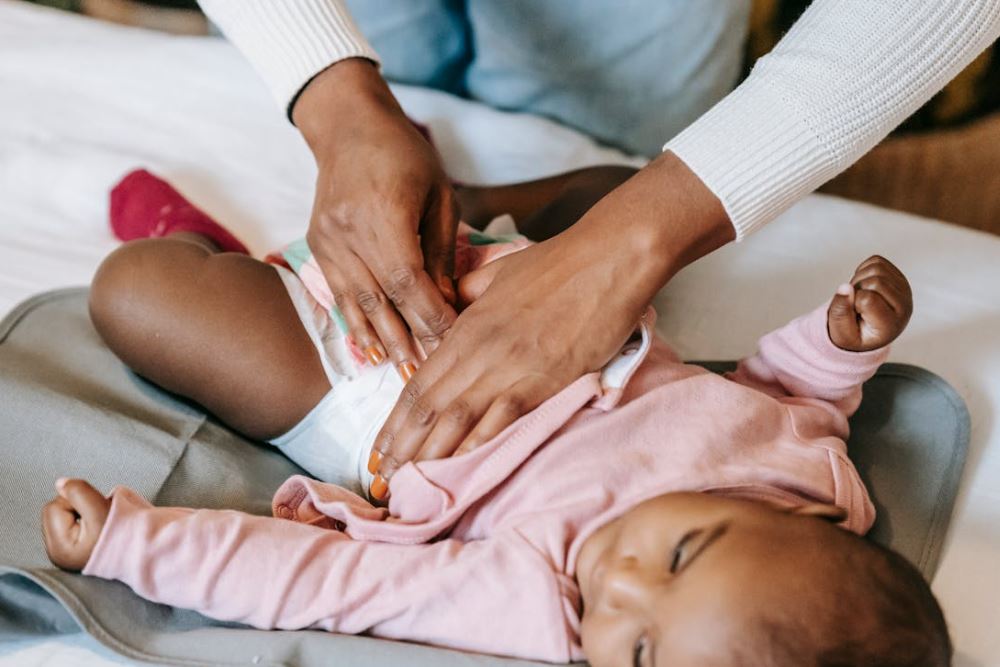 Une maman qui change la couche de son bébé